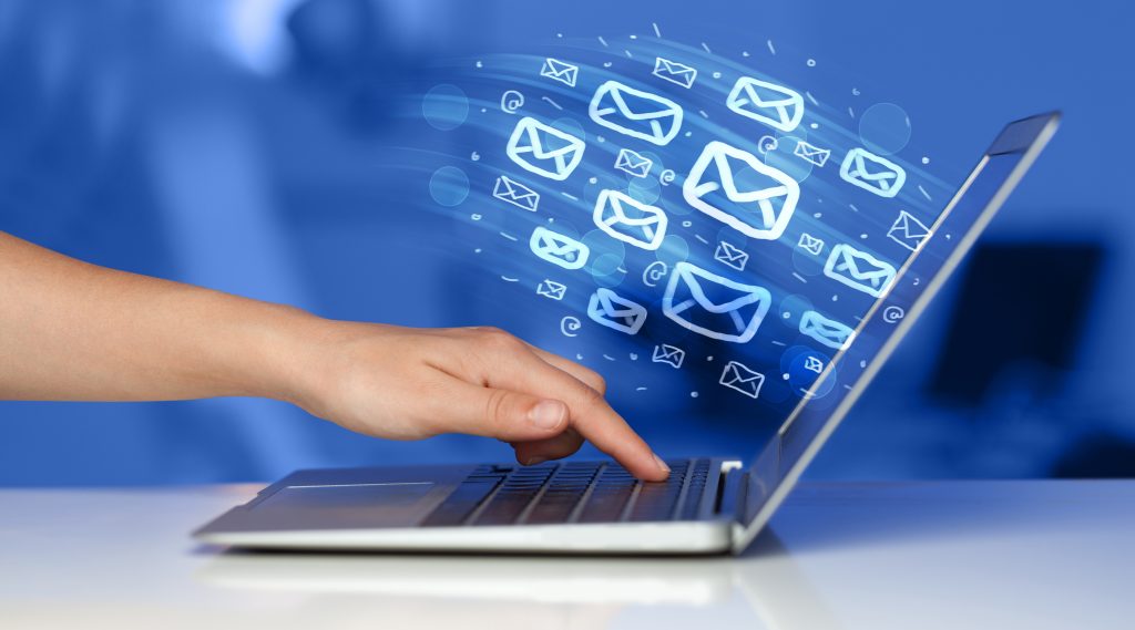 laptop with email icons flowing out of screen