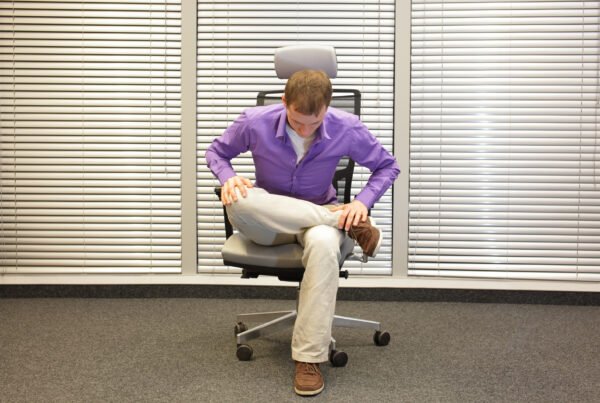 Man exercising on chair in office, healthy lifestyle