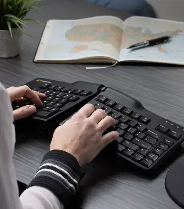 Goldtouch Elite Keyboard with a woman typing on the keyboard lifestyle image.